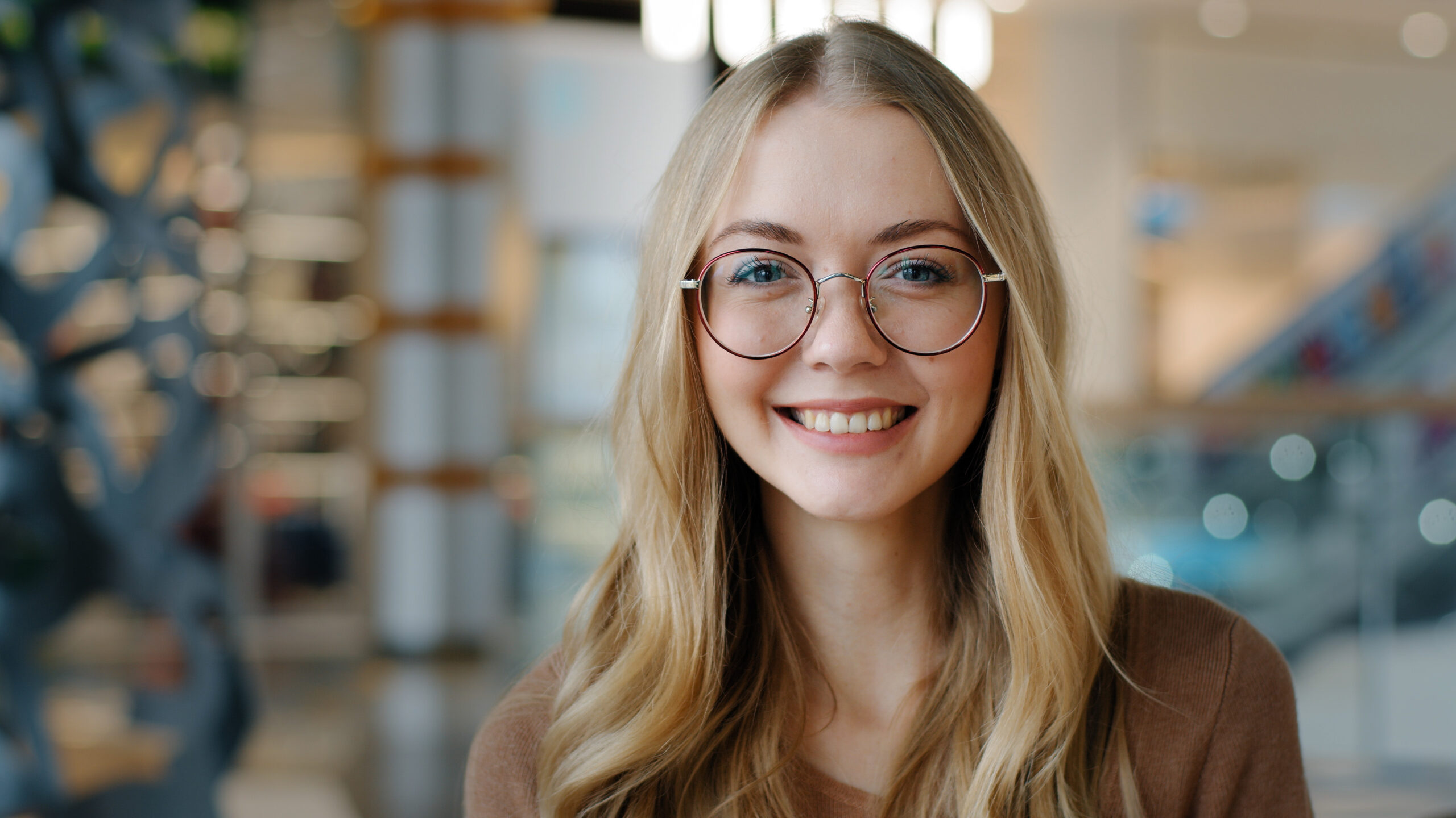 Head shot happy portrait caucasian girl in glasses young woman satisfied with ophthalmology services millennial blonde with healthy white toothy smile looking at camera confident model posing indoors. High quality photo